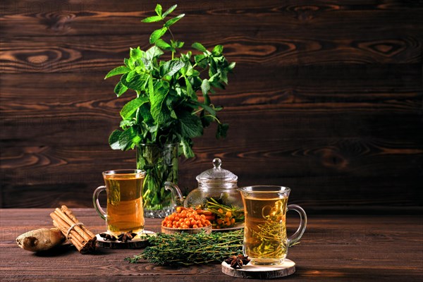 Restorative sea-buckthorn drink with thyme and cinnamon on wooden table