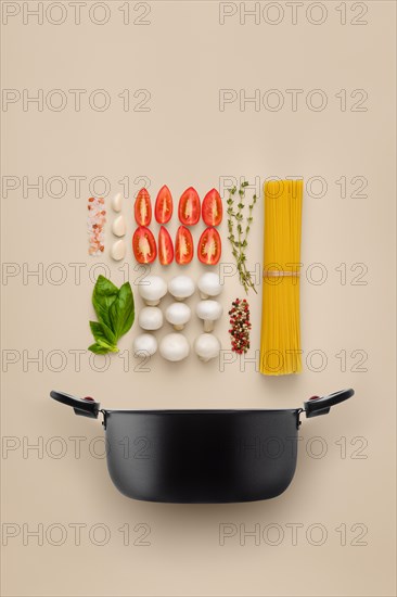 Recipe of spaghetti pasta organized into component parts over solid background