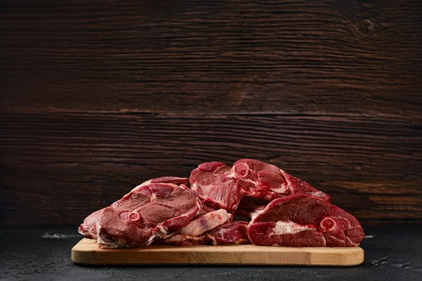 Assortment of raw fresh lamb meat on wooden tray