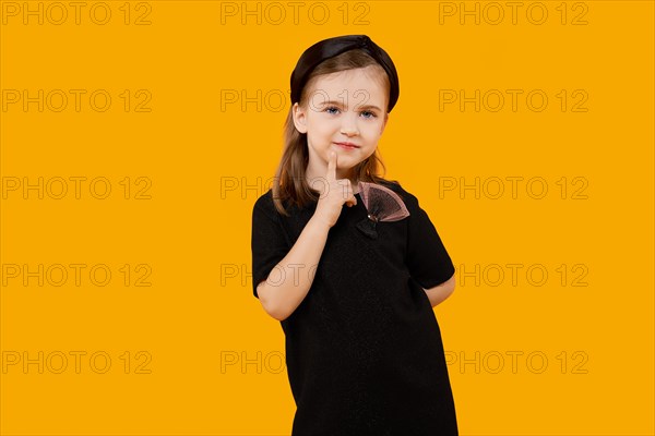 Cute young model girl in retro black tulle dress and hair band touching her chin