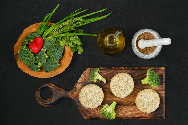 Top view of semifinished homemade chicken cutlet with broccoli on a wooden serving board