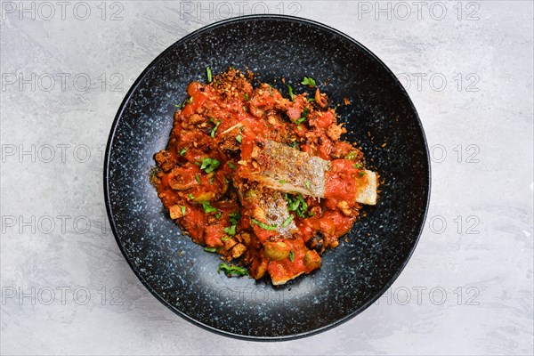 Top view of roasted zander served with steamed tomato