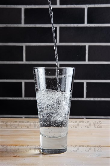 Pouring mineral water in highball glass. Lifestyle cafe shot