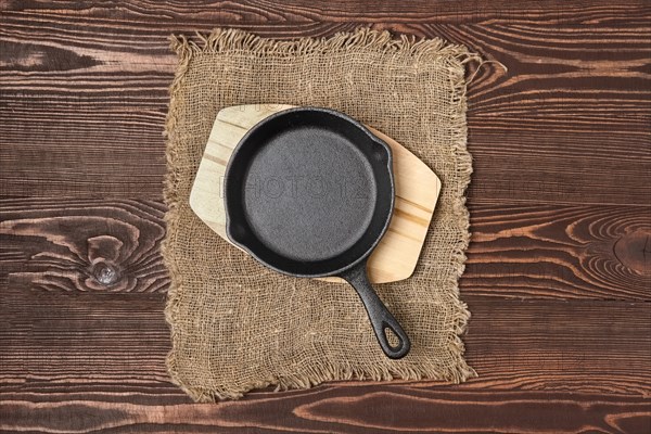 Empty mini cast-iron skillets on wooden table