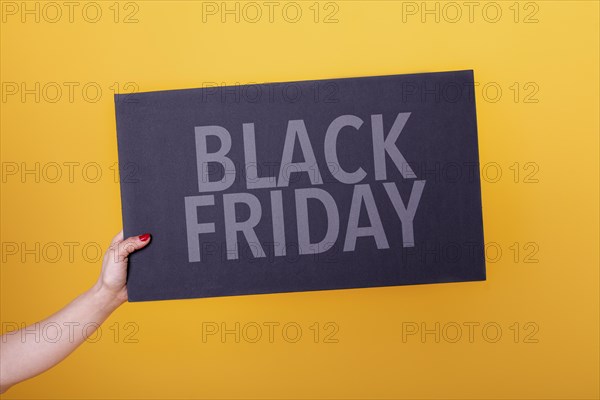 Female hand holding a black friday poster