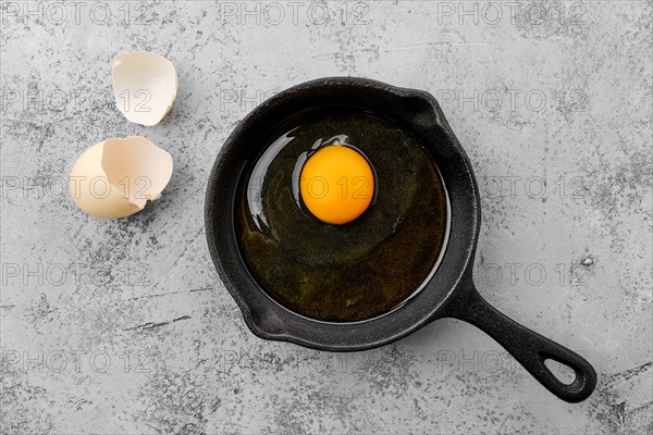 Raw uncooked egg in small cast iron skillet