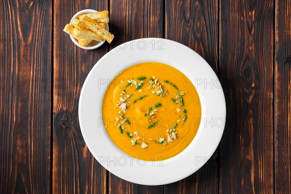 Overhead view of aubergine soup puree with pumpkin seed and crouton