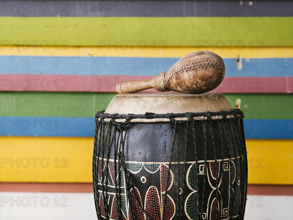 Percussion instruments alongside multicolored stripes wall with copy space