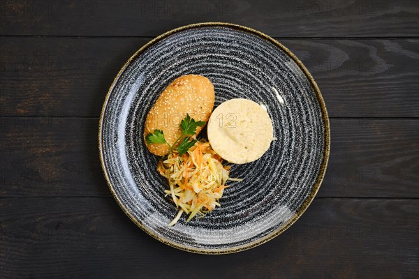 Top view of chicken cutlet stuffed with cheese served with millet porridge and pickled cabbage