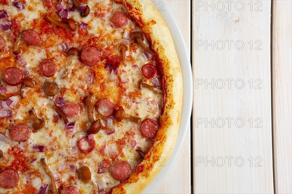 Top view of pizza with sausage and honey agaric