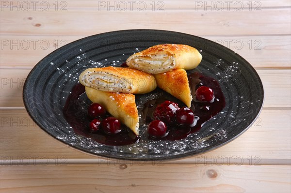 Thin pancakes with curd and cherry jam