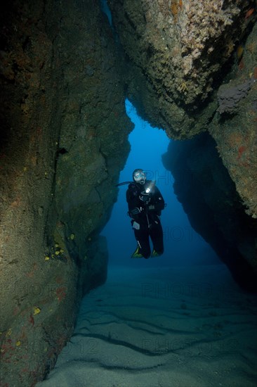 Natural tunnel in lava reef formed after primeval volcanic eruption