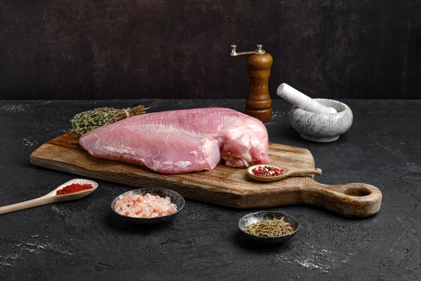 Raw fresh turkey boneless breast without skin on dark background