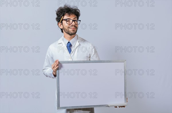 Professor in white coat holding small blank blackboard isolated. Scientist in glasses in a white coat is holding a blank whiteboard. Scientist showing blank whiteboard concept