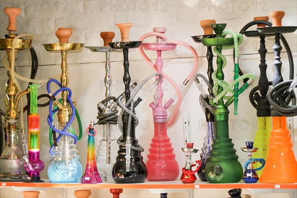 Group of eastern hookahs placed of various colors on a shelf