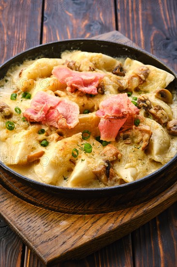 Close up view of pan with fried meat dumplings with bacon and mushroom sauce