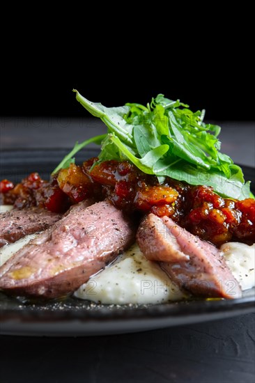 Roasted beef with caramelized vegetables and arugula