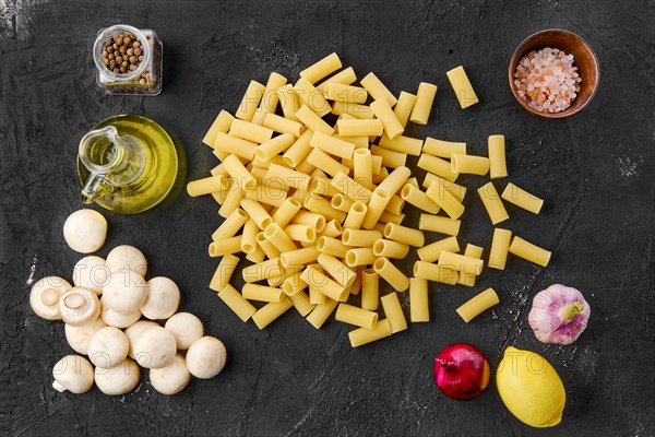 Overhead view of rigatoni pasta on black background