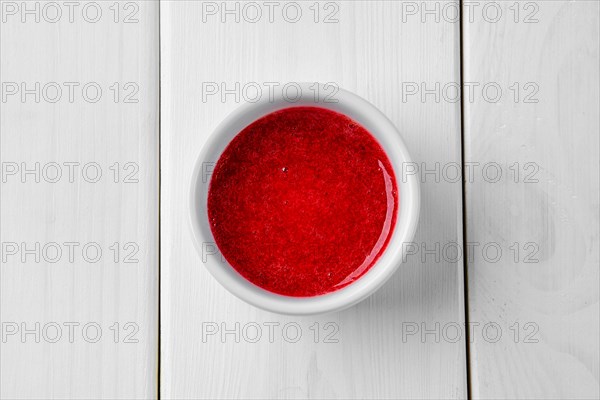 Top view of strawberry sauce in ceramic gravy boat