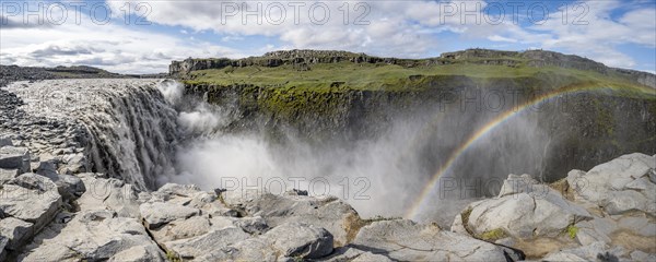 Canyon with falling water masses and rainbow