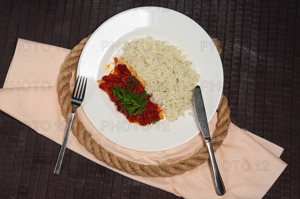 Top view of fried with spices white sea fish served with rice and dill