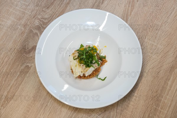 Top view of fried white fish fillet with quinoa porridge on wooden table