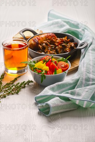 Cast-iron pan with fried sausage and mushrooms