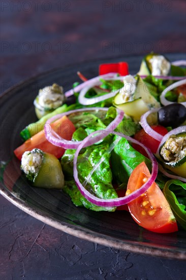 Fresh salad with zucchini stuffed with feta cheese with tomato