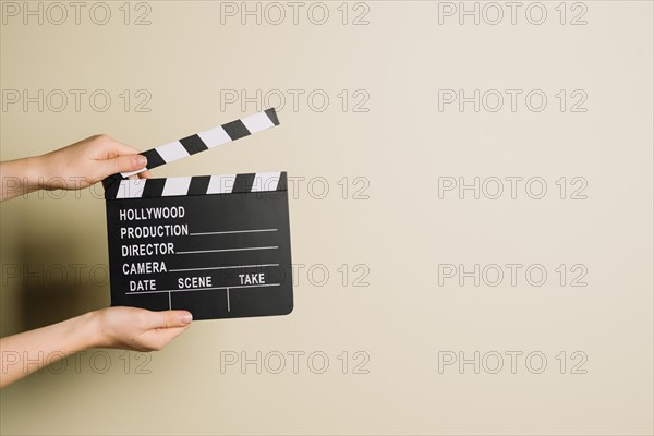 Crop hands with clapperboard