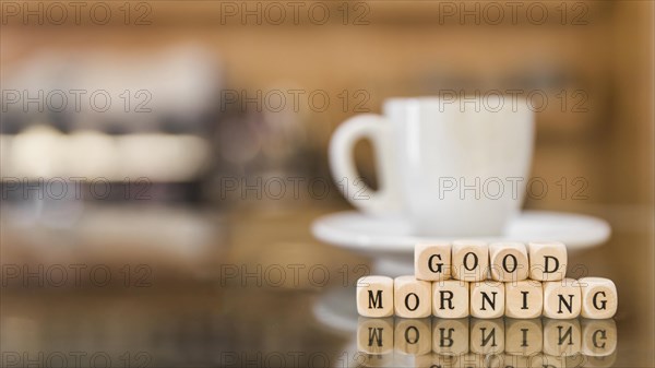 Good morning cubic blocks with cup coffee reflection glass