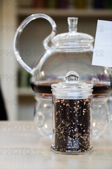 Herbal tea brewed in glass teapot and tea plant in a bottle