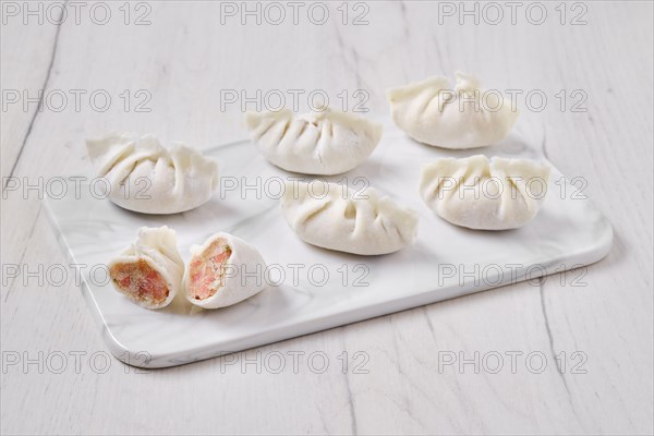 Frozen dumplings stuffed with liver and provencal herbs on marble serving plate