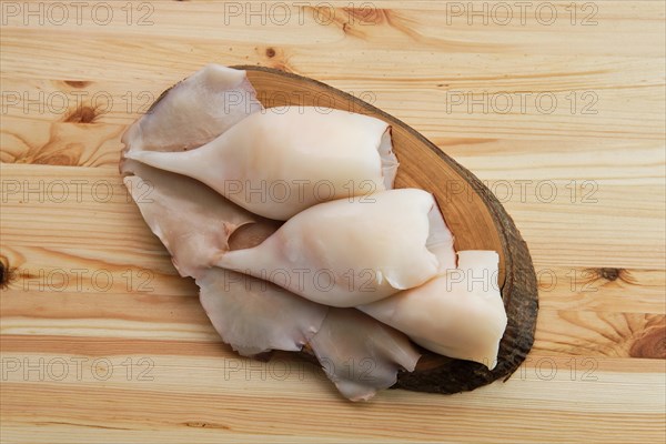 Top view of frozen pilled squid on wooden table