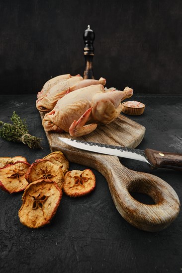 Three little raw chicken on wooden cutting board