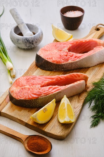 Raw fresh salmon steak on wooden cutting board