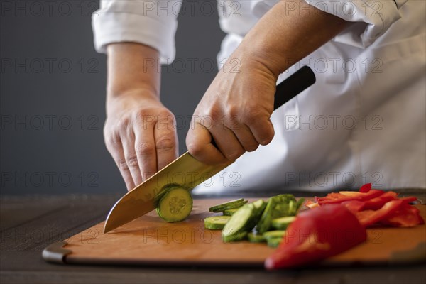 Close up hands cutting cucumber