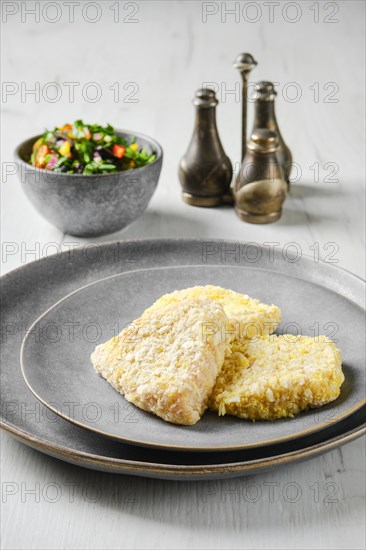 Semifinished squid cutlet in breading on a plate