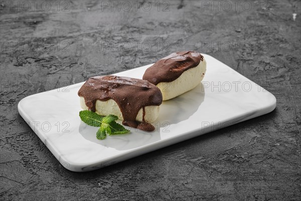 Glazed curd with chocolate on marble plate