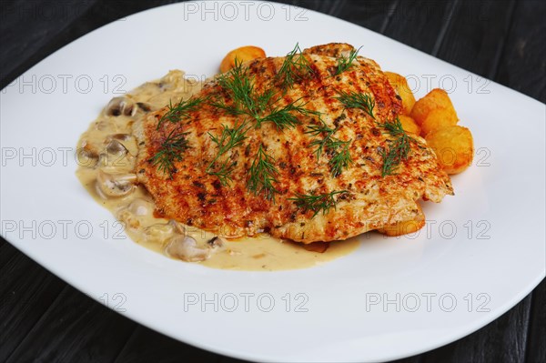 Fried chopped pork cutlet with potato balls and creamy sauce with mushroom and onion