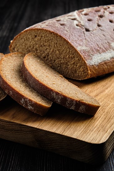 Close up view of yeast-free brown bread on wooden cutting board