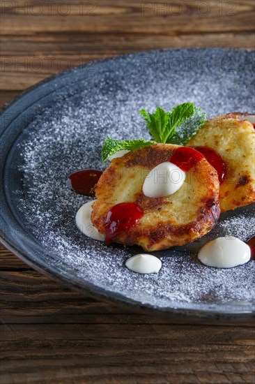 Cheese pancakes served with sour cream and strawberry jam