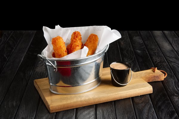 Snack for beer. Fried breaded cheese with sauce served in metal backet