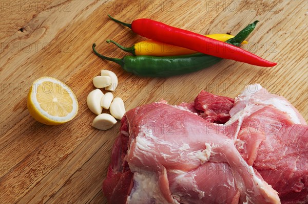 Fresh pork shoulder ready for baking with hot chilly and jalapeno pepper