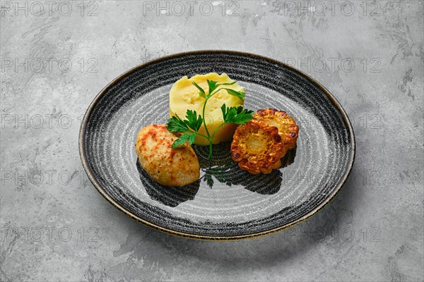 Ground meat cutlet with mashed potato and grilled corn slices