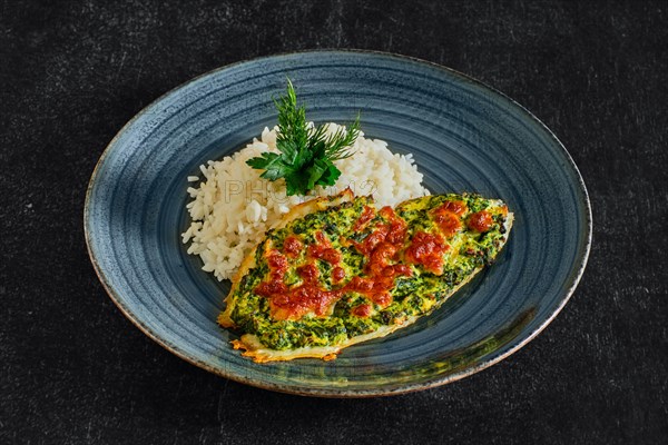 Fried fillet of white fish with spinach and cheese topping and served with rice