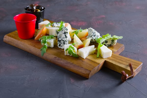Cheese plate with honey and black and yellow olives