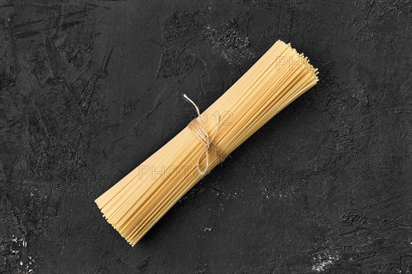 Top view of raw spaghetti on black background