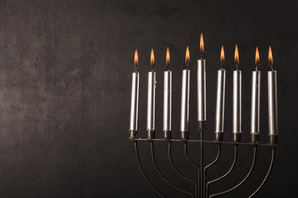 Menorah with candles near gray wall