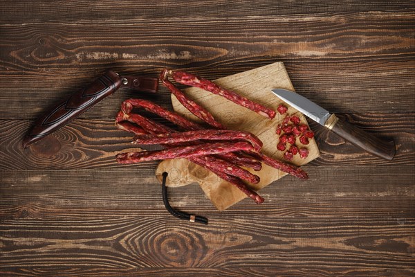 Overhead view of air dried deer and pork sausage on wooden background