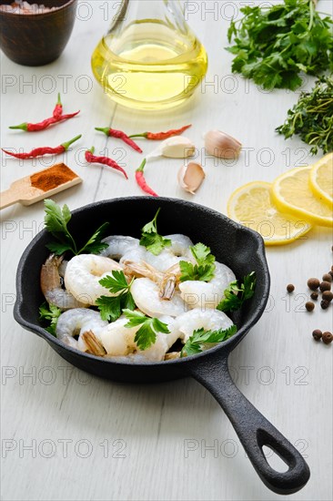 Top view of pan with fresh raw prawn with spice and herbs